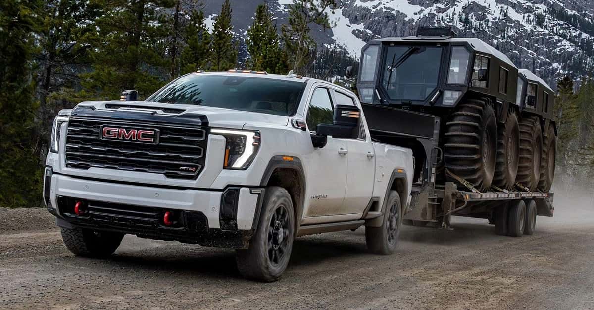 GMC Sierra HD towing motorized vehicles up a mountain road