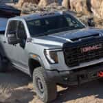 2026 GMC Sierra HD towing an overland-style camper trailer