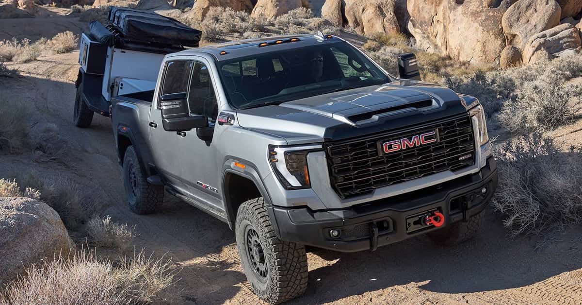 2026 GMC Sierra HD towing an overland-style camper trailer