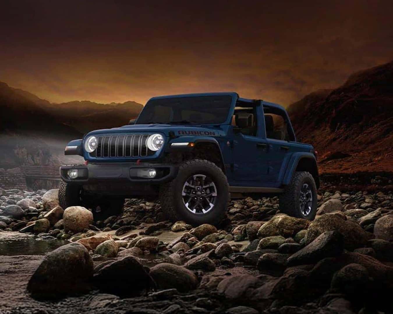 Side profile shot of the 2026 Jeep Wrangler parked on rocks at dusk.