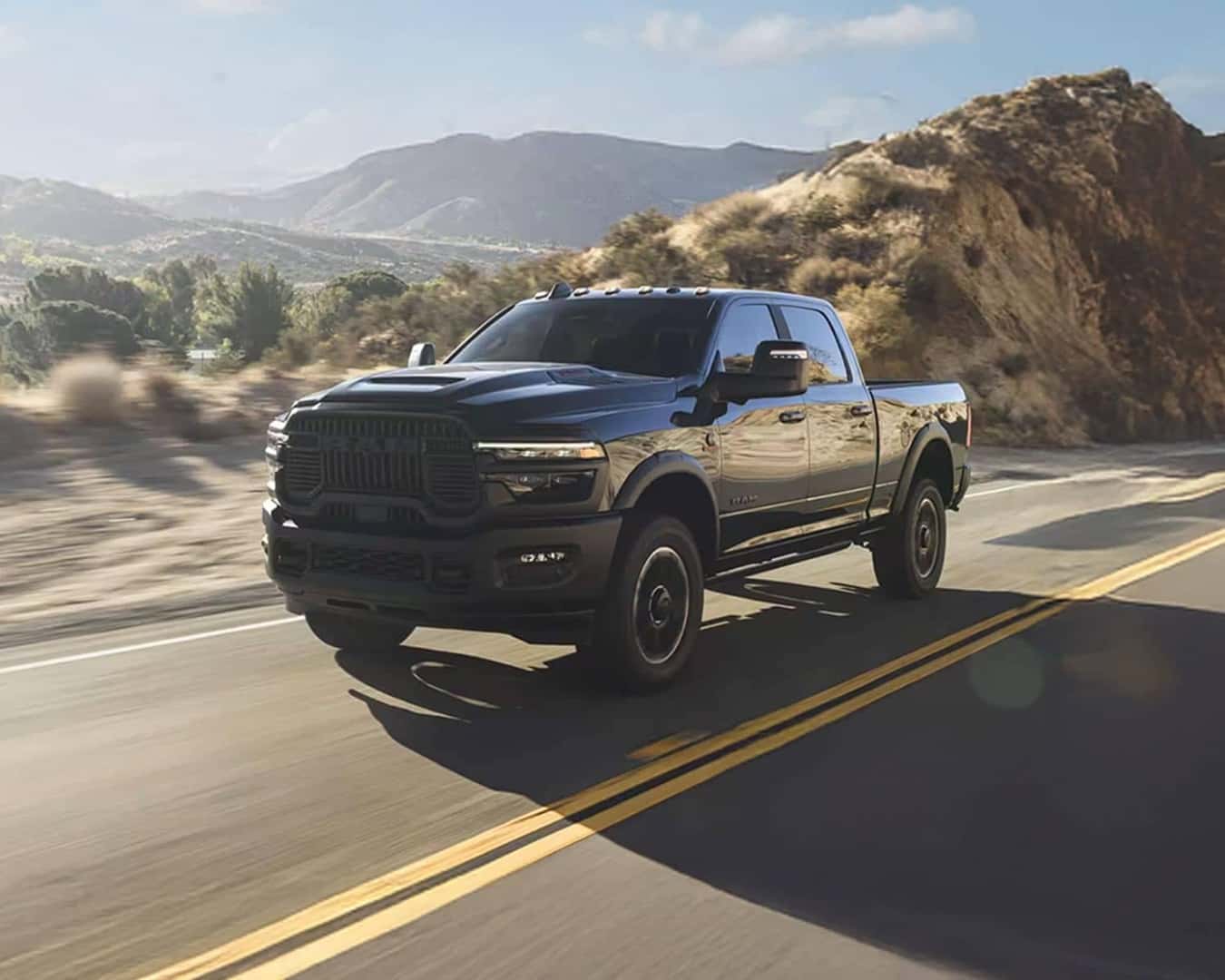 Front 3/4 shot of the 2026 RAM 2500 driving down road.