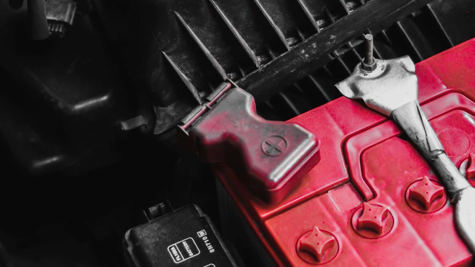 Close-up of a car battery terminal and hold-down clamp