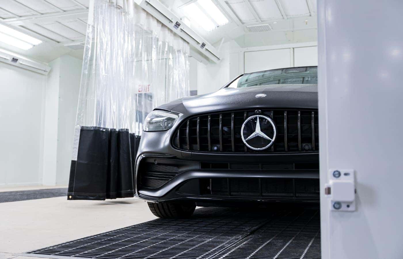 Black Mercedes-Benz in a painting enclosure at MBW Luxury Collision