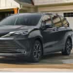 Dark gray 2026 Toyota Sienna parked on a residential driveway being washed by a family.