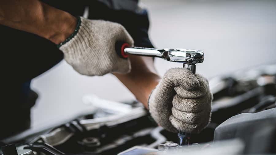 Close-up of a car mechanic repairing a car in a garage. car safe
