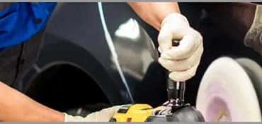 mechanic buffing paint on vehicle