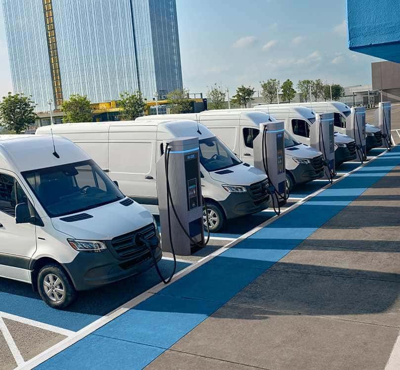 Mercedes-Benz vans charging in a fleet lot