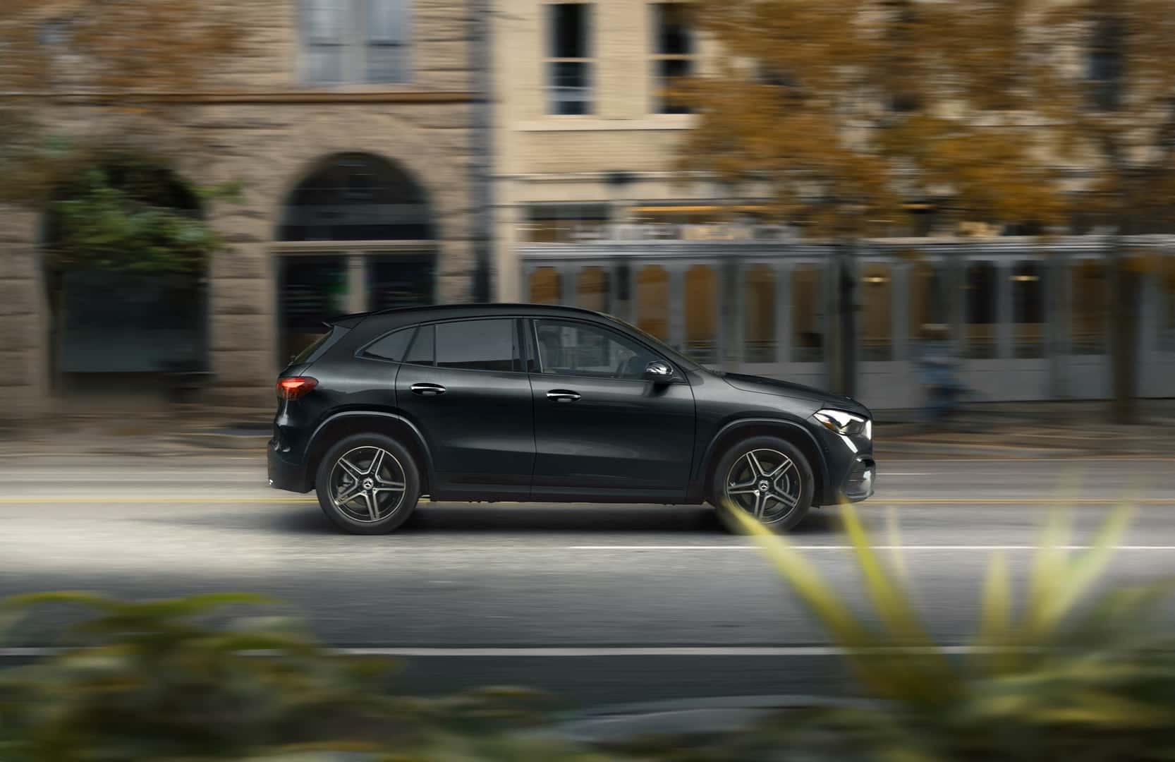 A black Mercedes-Benz GLA SUV driving on the road.