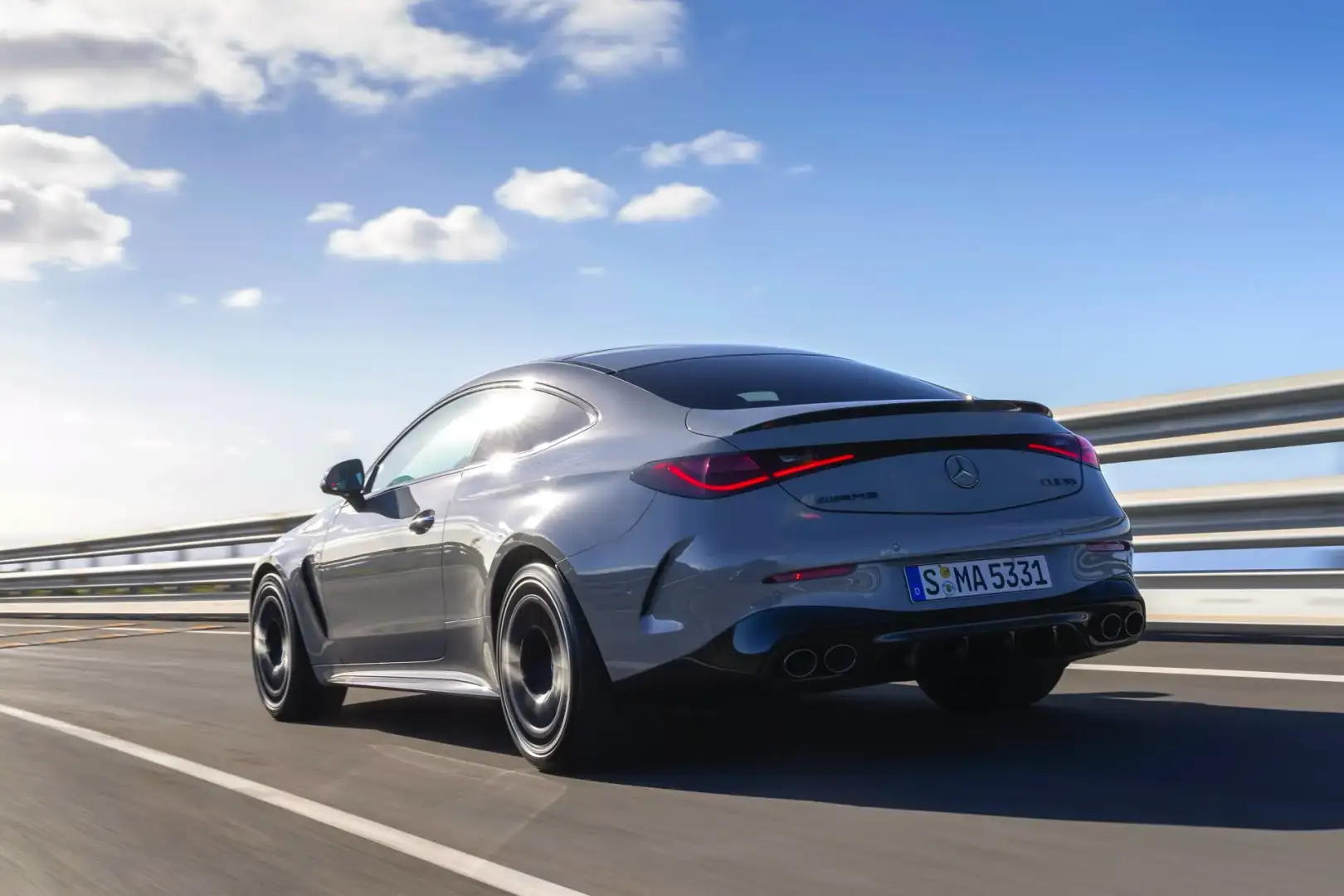 2025 Silver Mercedes AMG CLE Coupe rear view driving on a road 