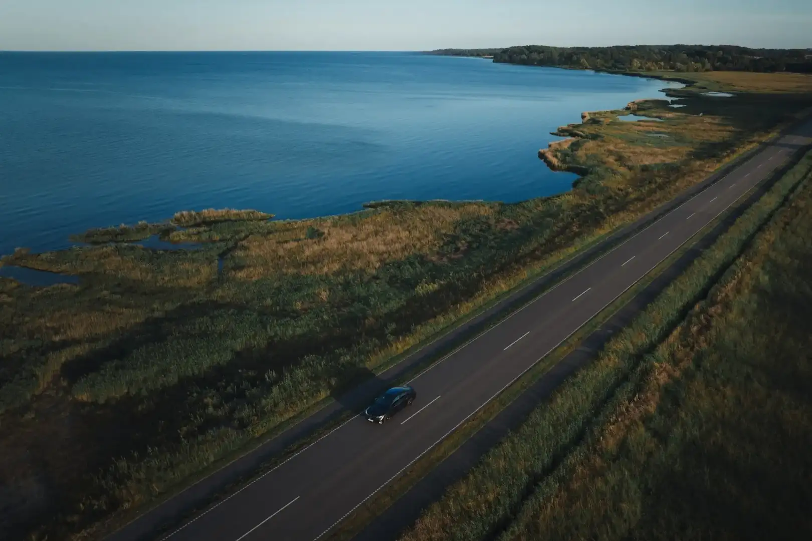 Mercedes Benz CLA driving on a road by a lake arial view