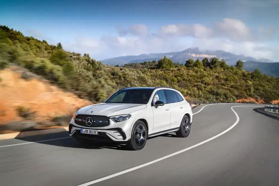 White Mercedes-Benz GLC 300 view of the front driving on a winding mountain road