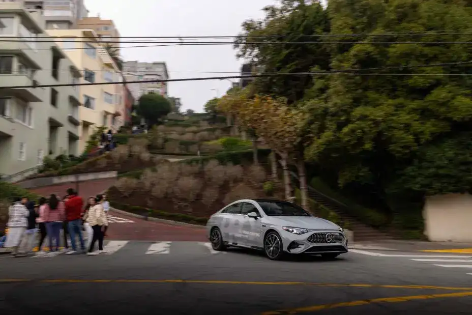 2026 Mercedes-Benz CLA driving on a city street going around a corner