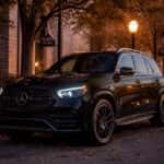 2027 Mercedes-Benz GLE on a tree-lined Plano street at dusk in late October