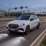 2027 Mercedes-Benz GLE with DIGITAL LIGHT headlamps illuminating a Plano Texas parkway at dusk