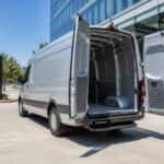 2026 Mercedes-Benz Sprinter cargo van with rear doors open outside a Legacy corridor office building in Plano, TX
