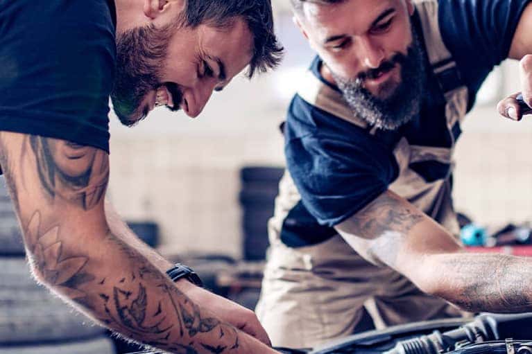 Two-mechanics-work-together-on-a-car-engine_mobile