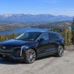 2027 Cadillac OPTIQ parked at Spooner Summit overlook on US-50 with Spooner Lake and the Carson Range in the background
