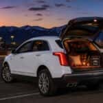 2026 Cadillac XT5 with liftgate open at a Carson City trunk-or-treat event, dusk lighting and Carson Range in the background