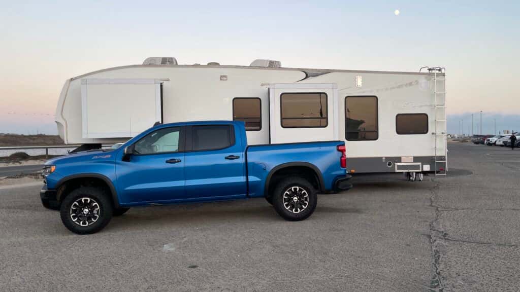 2024 Chevy Silverado Driver Side View Parked in Front of White Camper