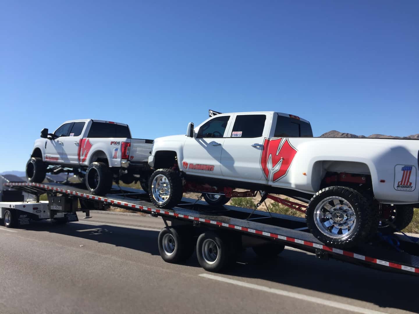 Two White Trucks on Towing Trailer