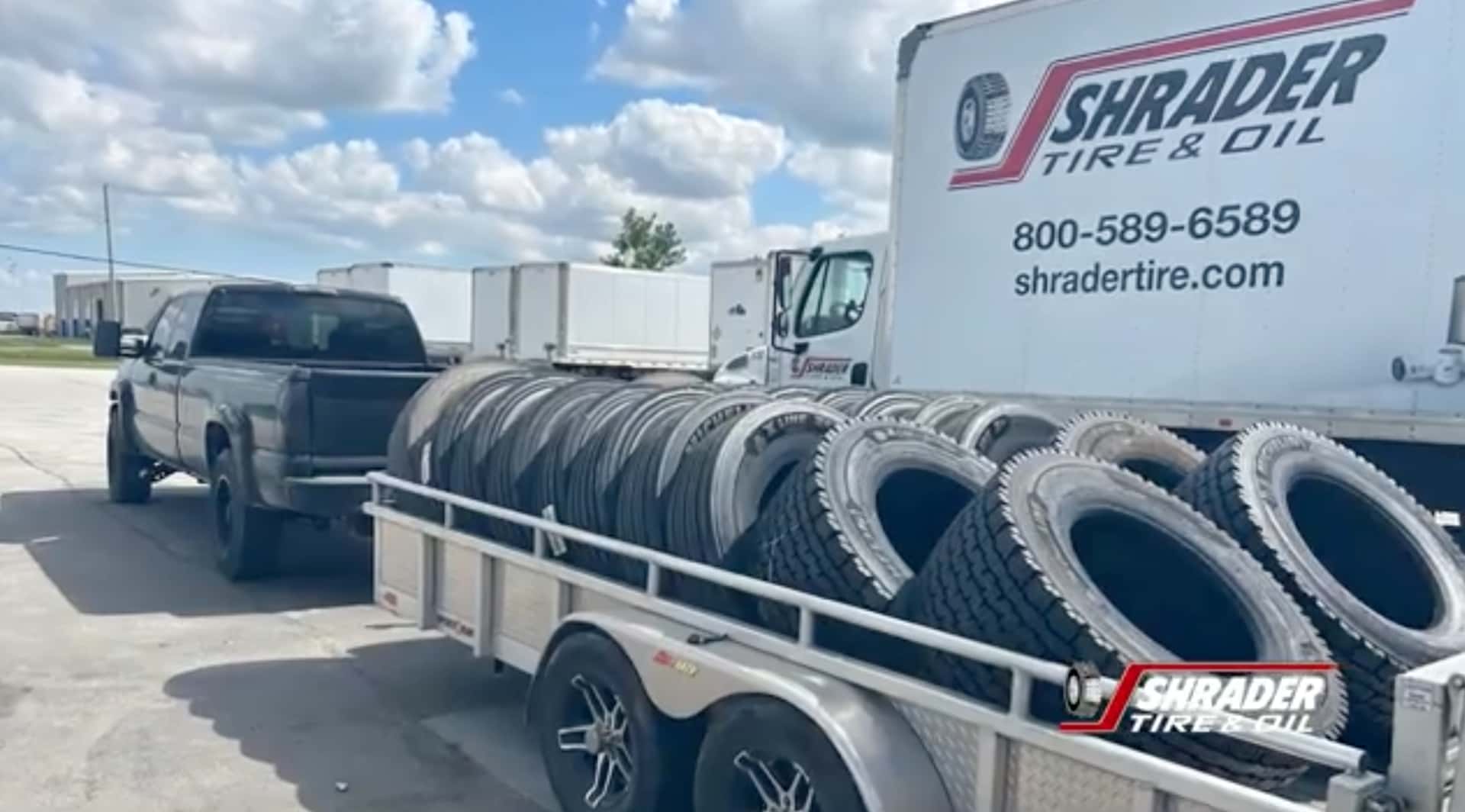 The Durable GMC Silverado With A Metallic Trailer Of Tires Hitched To It