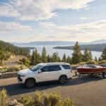 2026 Chevrolet Tahoe towing a boat trailer at Spooner Summit on US-50 with Lake Tahoe in the background