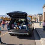2026 Chevrolet Traverse with open liftgate at a Carson City school drop-off, backpacks and sports gear loaded in cargo area