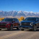 2026 Chevrolet Traverse and 2026 Chevrolet Tahoe parked side by side on a Nevada highway with the Sierra Nevada in the background