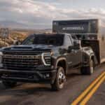 2026 Chevrolet Silverado 2500 HD towing a gooseneck trailer on a Nevada highway in high-desert terrain