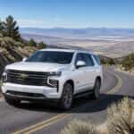 2026 Chevrolet Tahoe climbing a switchback mountain road near Virginia City, Nevada with Carson Valley visible below