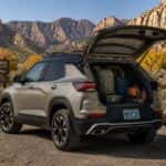 2026 Chevrolet Trailblazer ACTIV parked at Kings Canyon trailhead in Carson City, NV, rear liftgate open with hiking gear loaded, fall sky above the canyon walls