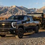 2026 Chevrolet Silverado 2500 HD with a gooseneck trailer on a high-desert gravel road near Carson City, Nevada with mountains in the background