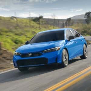 2026 Honda Civic Hatchback Sport Touring Hybrid Boost Blue Pearl in motion