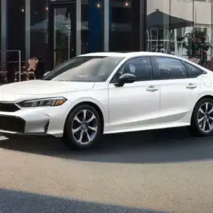 2026 Honda Civic Sedan Sport Touring Hybrid Platinum White Pearl parked in a city