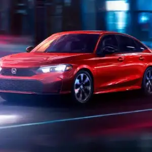 2026 Honda Civic Sedan Sport Touring Hybrid Rallye Red in motion