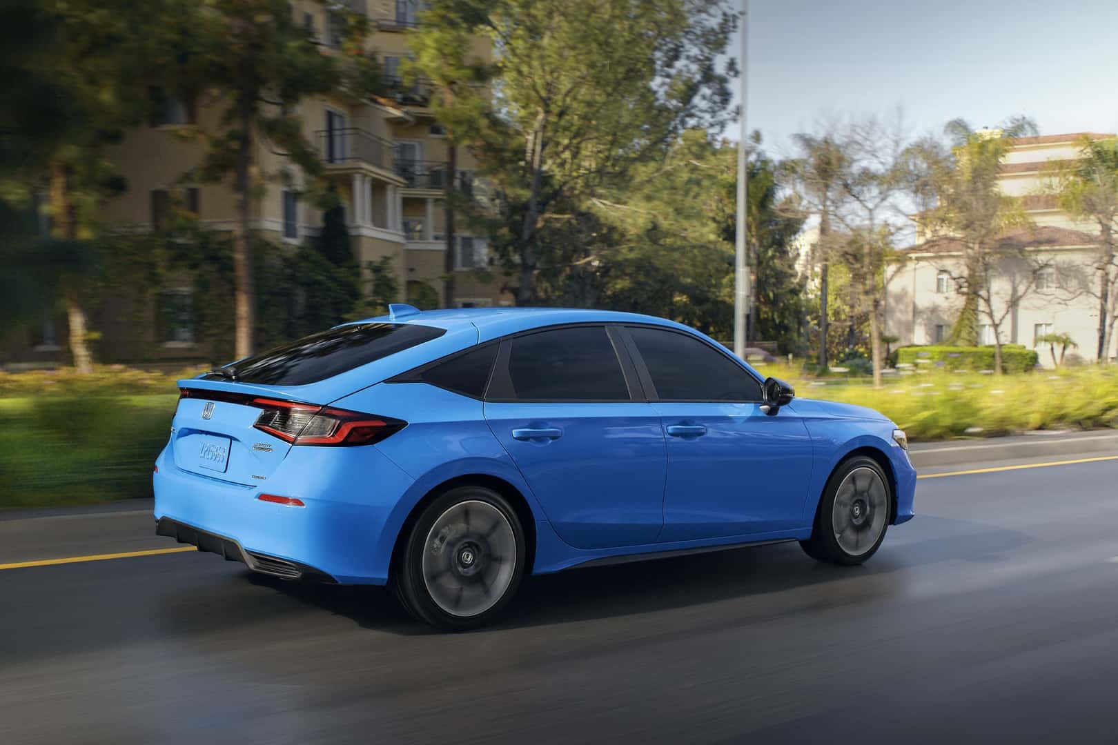 The Affordable And Inexpensive Honda Civic Hatchback Sport Touring Hybrid Driving On Concrete Streets