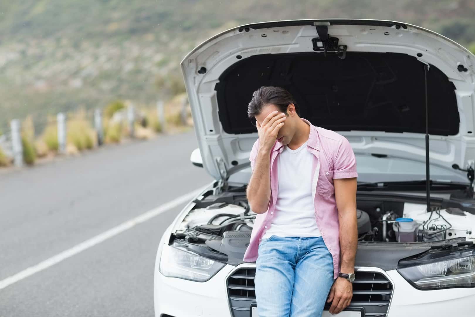 Perplexed Man Sitting on the Hood of a Car