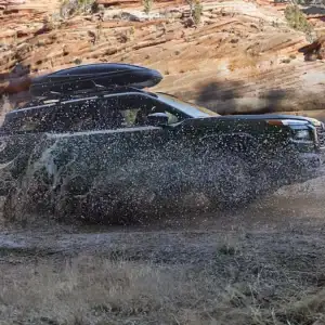 2026 Subaru Outback Touring Deep Emerald Green Pearl driving through water