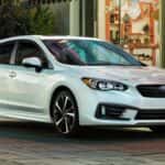 The Affordable And Shining 2023 Subaru Impreza Parked Outside A Street Shop