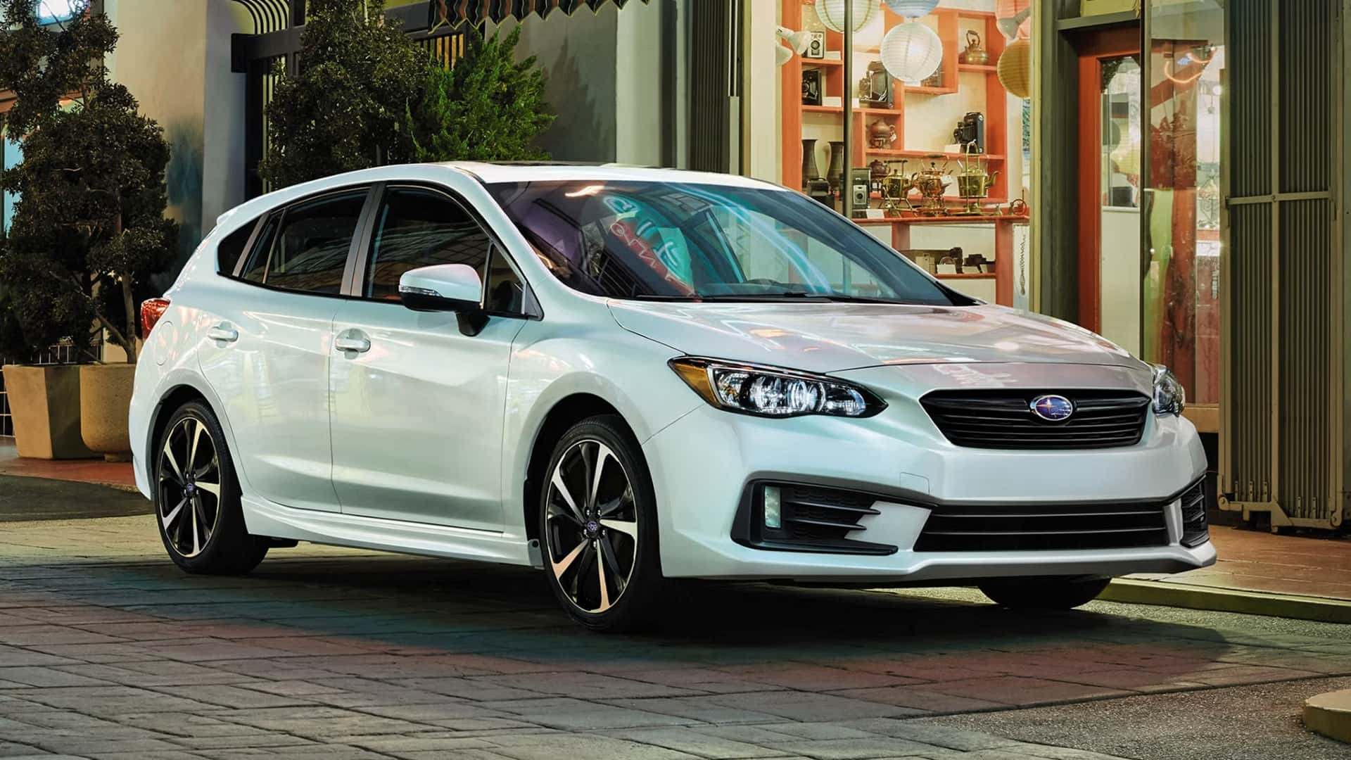The Affordable And Shining 2023 Subaru Impreza Parked Outside A Street Shop