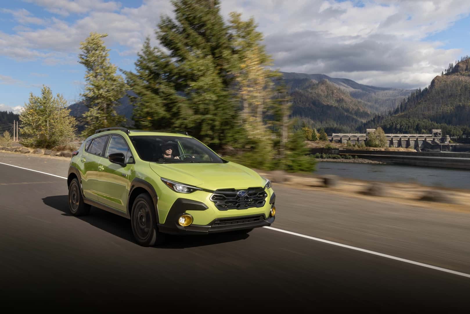 The Affordable And Efficient 2026 Subaru Crosstrek Hybrid Driving Past Beautiful Scenery