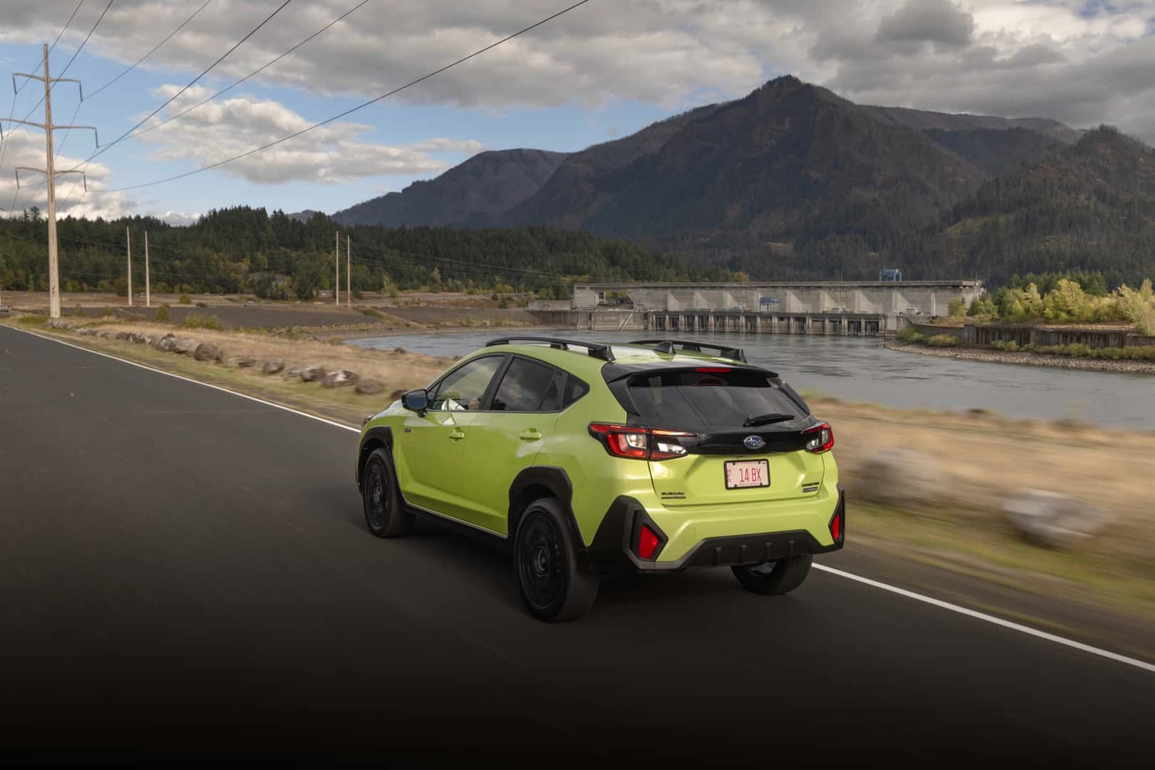 The Rear View Of The Practical And Useful 2026 Subaru Crosstrek Hybrid As It Drive Past Beautiful Scenery