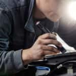 A service technician under the hood of a vehicle in the service center.