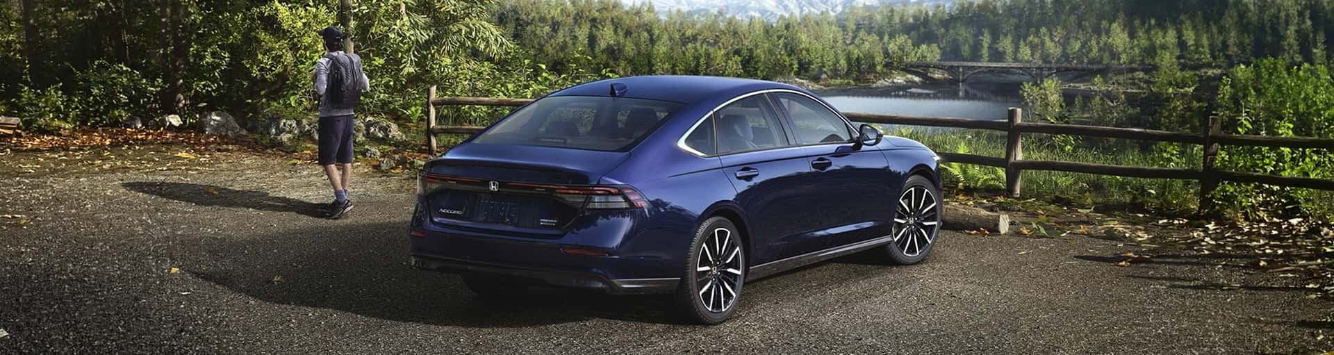 A blue Honda Accord Hybrid Touring parked by a lake.