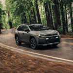 A 2026 Toyota RAV4 driving through a wooded area