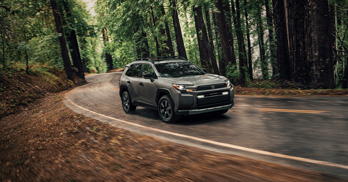 A 2026 Toyota RAV4 driving through a wooded area