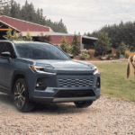 A Toyota RAV4 Hybrid parked on the dirt driveway of a farm.