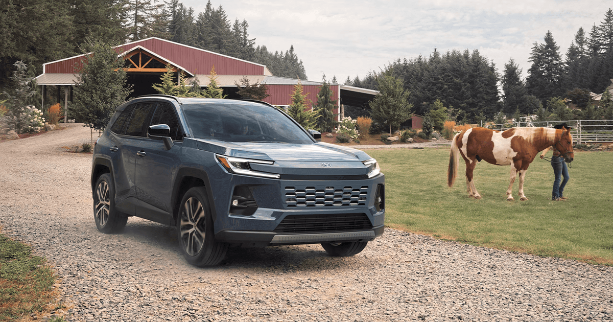 A Toyota RAV4 Hybrid parked on the dirt driveway of a farm.
