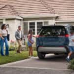 A family getting into their Toyota RAV4 parked in the driveway.