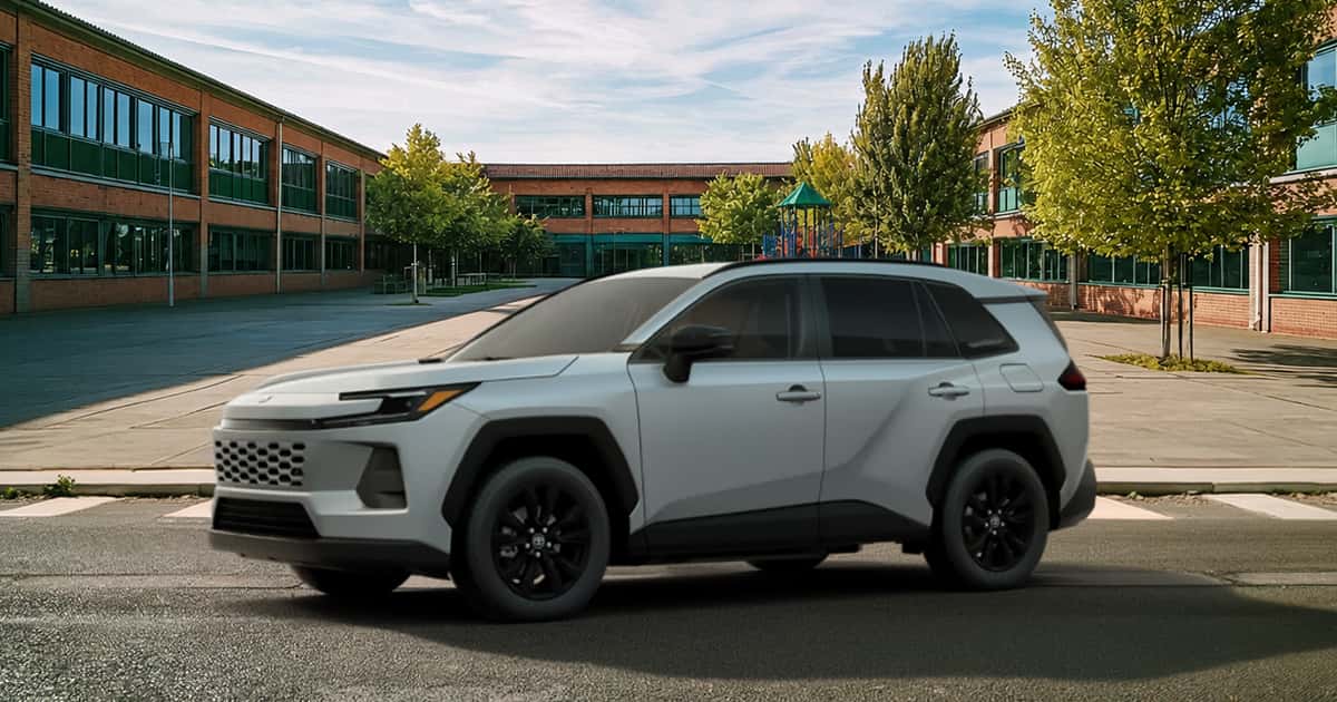 A Toyota RAV4 in the Wind Chill Pearl exterior color parked on a city street.